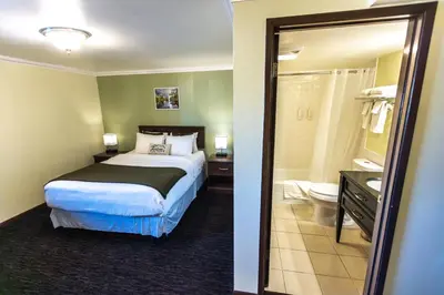 a bedroom with a bed and a bathroom with a mirror at The Mammoth Creek Inn in Mammoth Lakes