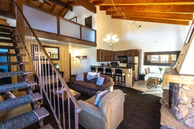 a living room with a staircase and a living room at The Mammoth Creek Inn in Mammoth Lakes