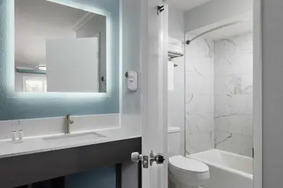 a bathroom with a toilet and a sink and a mirror at Red Lion Inn & Suites Lemoore in Lemoore
