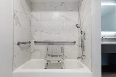 a white bathroom with a chair in a sink at Red Lion Inn & Suites Lemoore in Lemoore