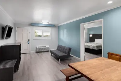 a living room with a table and a bedroom at Red Lion Inn & Suites Lemoore in Lemoore