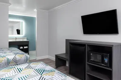 a bedroom with a bed and a flat screen tv on a wall at Red Lion Inn & Suites Lemoore in Lemoore