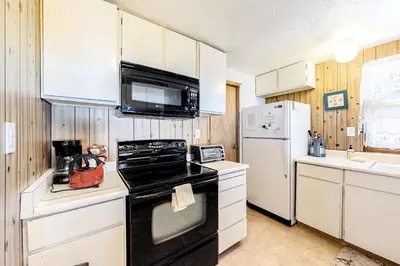 a kitchen with a black stove and a refrigerator at Picture Perfect Chalet in Prosser Lakeview Estates