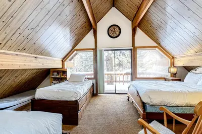 two beds in a room with wooden ceilings at Picture Perfect Chalet in Prosser Lakeview Estates