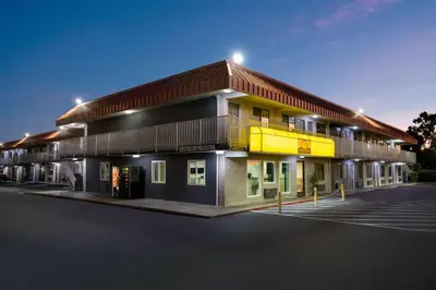 a building with a parking lot in front of it at Days Inn by Wyndham Fresno South in Fresno