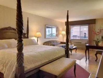 a bedroom with a bed and a living room at Merced Inn & Suites in Merced