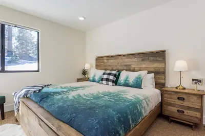 a bedroom with a large bed with a wooden headboard at Crestview 35 in Mammoth Lakes