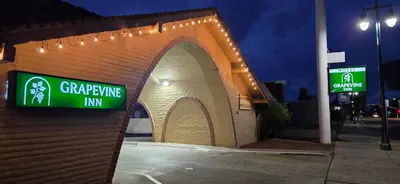 a brick building with a sign that reads gardening inn at Grapevine Inn in Lodi