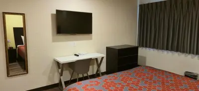 a bedroom with a bed and a mirror and a tv at Grapevine Inn in Lodi