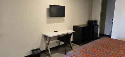 a room with a desk and a tv on the wall at Grapevine Inn in Lodi