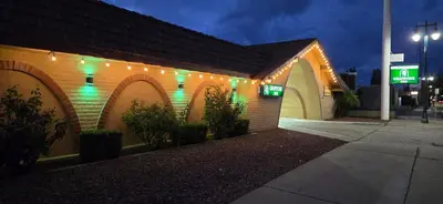 a building with green lights on the side of it at Grapevine Inn in Lodi