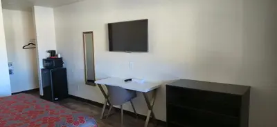 a hotel room with a bed and a television on the wall at Grapevine Inn in Lodi