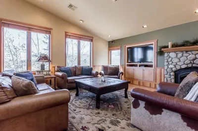 a living room with couches and a fireplace and a tv at Snowcreek V 820 in Mammoth Lakes