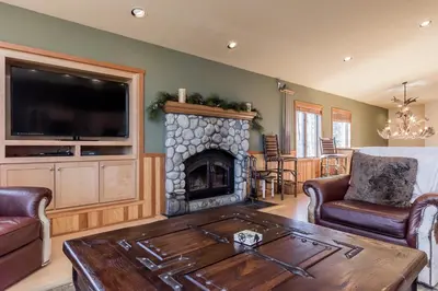 a living room with a fireplace and a tv at Snowcreek V 820 in Mammoth Lakes