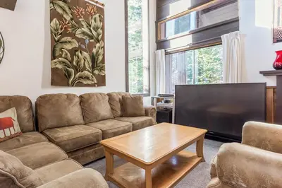 a living room with a couch and a flat screen tv at Mammoth Ski and Racquet 132 in Mammoth Lakes