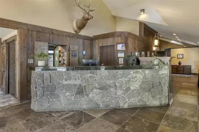 a large lobby with a stone bar with a deer head on the wall at Best Western Plus Truckee-Tahoe Hotel in Truckee