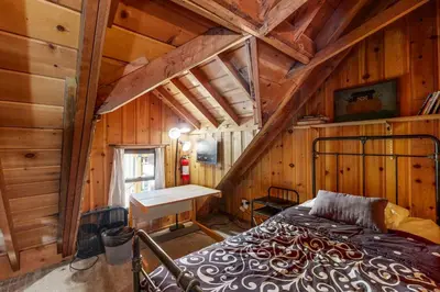 a bedroom with a bed in a wooden cabin at Donner Lake Dream Cabin in Donner Lake Village