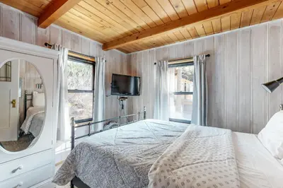 a bedroom with a bed and a mirror and a tv at Donner Lake Dream Cabin in Donner Lake Village
