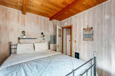 a bedroom with a bed in a room with wooden walls at Donner Lake Dream Cabin in Donner Lake Village