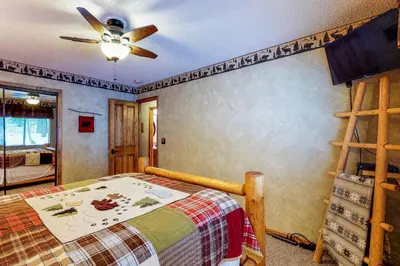 a bedroom with a bed and a ceiling fan at Saxon Creek in Mevers