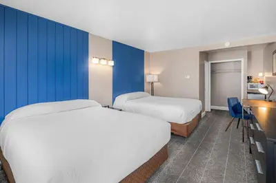 two beds in a hotel room with blue walls at The Inn at Boatworks, Lake Tahoe in Tahoe City