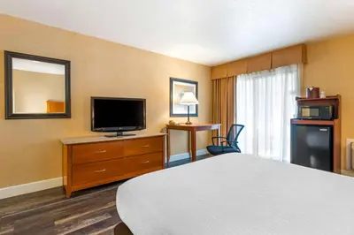 a hotel room with a bed and a flat screen tv at Best Western Plus Placerville Inn in Placerville