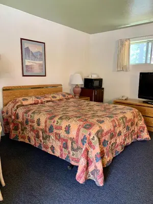 a bedroom with a bed and a flat screen tv at Stevenson’s Inn in Kings Beach