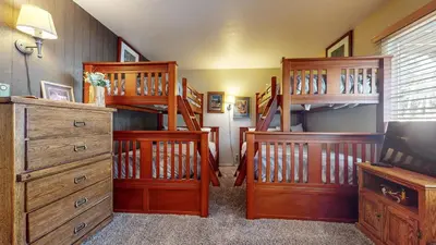 a room with wooden bunk beds and a television at Chateau De Montagne #1 Condo in Mammoth Lakes