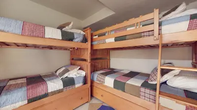 a bedroom with three bunk beds in a cabin at Mammoth West #140 Condo in Mammoth Lakes