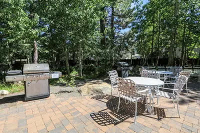 a patio with a table and chairs and a grill at Chateau De Montagne #15 Condo in Mammoth Lakes