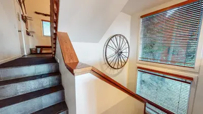 a staircase with a wheel on the wall next to a window at Bridges Townhome #09 Condo in Mammoth Lakes
