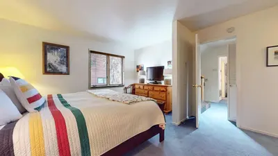 a bedroom with a bed and a dresser and a television at Bridges Townhome #09 Condo in Mammoth Lakes