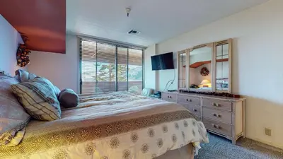 a bedroom with a bed and a dresser and a mirror at Bridges #105 Condo in Mammoth Lakes