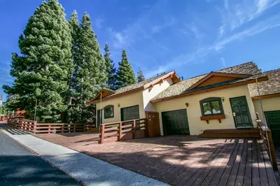 a house with a fence and a pine tree at Bridges Townhome #07 Condo in Mammoth Lakes
