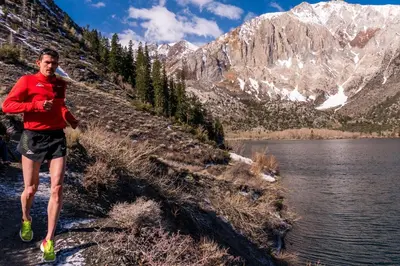 a man running on a trail next to a lake at Bridges Townhome #07 Condo in Mammoth Lakes
