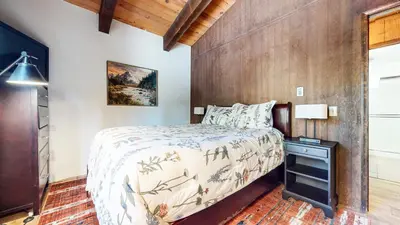 a bedroom with a bed and a wooden wall at Chateau De Montagne #17 Condo in Mammoth Lakes