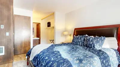 a bedroom with a large bed with a blue comforter at Chateau De Montagne #17 Condo in Mammoth Lakes
