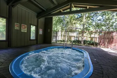 a jacuzzi tub in the middle of a house at Chateau De Montagne #17 Condo in Mammoth Lakes