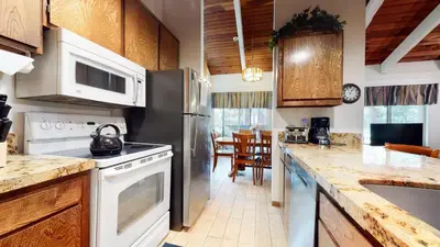 a kitchen with a stainless steel refrigerator and white appliances at Horizons 4 #188 Condo in Mammoth Lakes