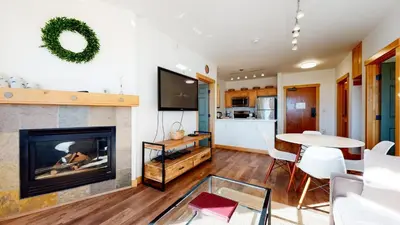 a living room with a fireplace and a table at Sunstone #109 Condo in Mammoth Lakes