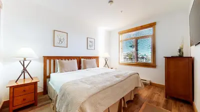 a bedroom with a large bed and a window at Sunstone #109 Condo in Mammoth Lakes