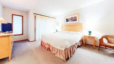 a bedroom with a large bed and a chair at Snowcreek V #933 Townhouse in Mammoth Lakes