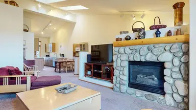 a living room with a large stone fireplace at Snowcreek V #933 Townhouse in Mammoth Lakes