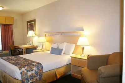 a hotel room with a bed and a chair at Days Inn by Wyndham Rocklin/Sacramento in Rocklin
