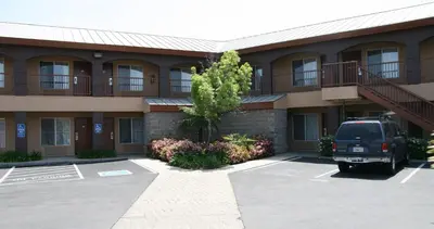 a building with a car parked in a parking lot at Days Inn by Wyndham Rocklin/Sacramento in Rocklin