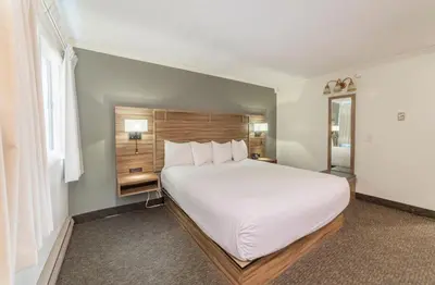 a bedroom with a large white bed and a window at Alpenhof Lodge in Mammoth Lakes