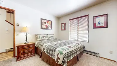 a bedroom with a bed and a window at Snowflower #49 Condo in Mammoth Lakes