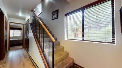 a staircase in a house with a large window at Snowflower #49 Condo in Mammoth Lakes