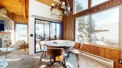 a dining room with a table and chairs and windows at Val D'Isere #35 Condo in Mammoth Lakes