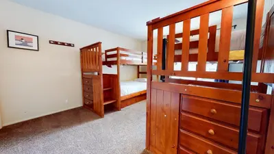 a bedroom with two bunk beds and a staircase at Chateau de Montagne #29 Condo in Mammoth Lakes